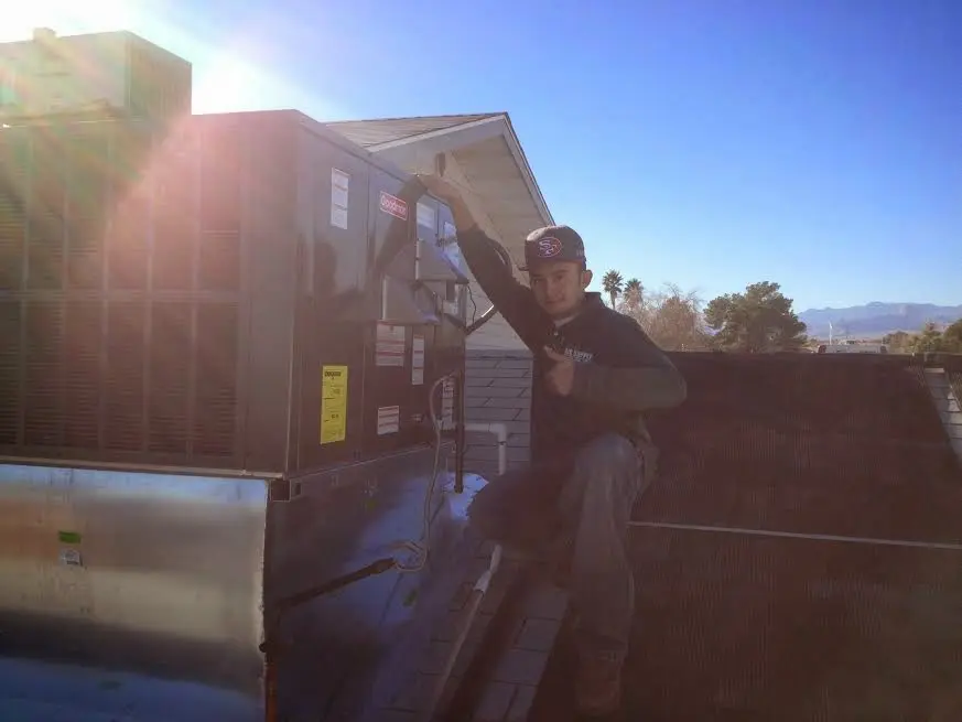 HVAC technician performing Air Duct Cleaning on a rooftop unit in Shaler